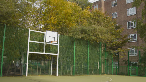 Künstlicher-Fußballplatz-Im-Städtischen-Stadtgebiet-Mit-Jungem-Paar,-Das-Fußball-Tritt-2