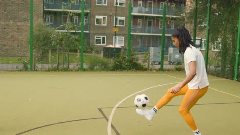 Junges-Paar,-Das-Fußball-Auf-Einem-Künstlichen-Fußballplatz-Im-Städtischen-Stadtgebiet-Tritt