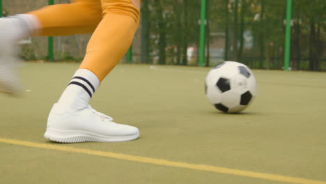 Close-Up-Of-Artificial-Soccer-Pitch-In-Urban-City-Area-With-Young-Couple-Kicking-Football-3