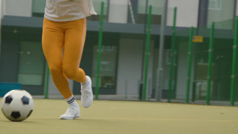 Joven-Con-Fútbol-Bajo-El-Brazo-En-Un-Campo-De-Fútbol-Artificial-En-El-área-Urbana-De-La-Ciudad