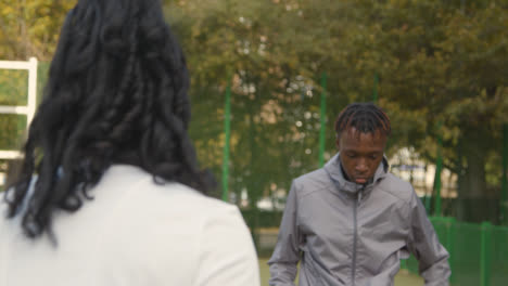 Junge-Spieler-Schießen-Und-Retten-Fußball-Auf-Künstlichem-Fußballplatz-Im-Städtischen-Stadtgebiet