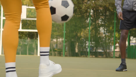 Junge-Spieler,-Die-Fußball-Auf-Einem-Künstlichen-Fußballplatz-Im-Städtischen-Gebiet-Treten-Und-Weitergeben
