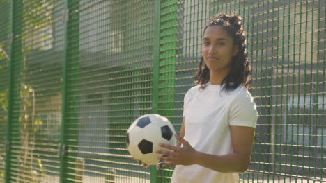 Porträt-Einer-Jungen-Frau-Gegen-Zaun-Auf-Einem-Künstlichen-Fußballplatz-Im-Städtischen-Stadtgebiet