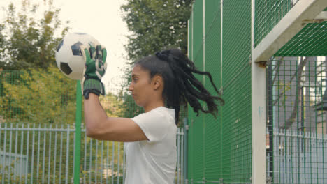 Junge-Fußballspieler-Schießen-Und-Retten-Einen-Schuss-Auf-Das-Tor-Auf-Einem-Künstlichen-Fußballplatz-Im-Städtischen-Gebiet