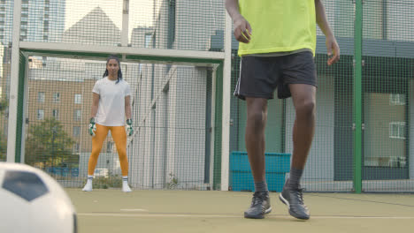 Portero-De-Fútbol-Femenino-Salvando-Un-Tiro-A-Portería-En-Un-Campo-De-Fútbol-Artificial-En-El-área-Urbana-De-La-Ciudad