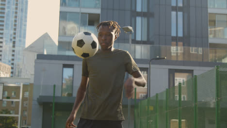 Männlicher-Fußballspieler,-Der-Ballkontrolle-Auf-Künstlichem-Fußballplatz-Im-Städtischen-Gebiet-übt