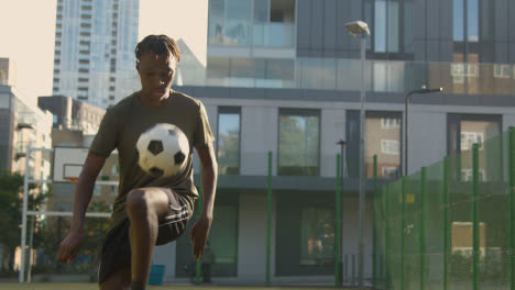 Männlicher-Fußballspieler-übt-Ballkontrolle-Auf-Künstlichem-Fußballplatz-Im-Städtischen-Stadtgebiet-1