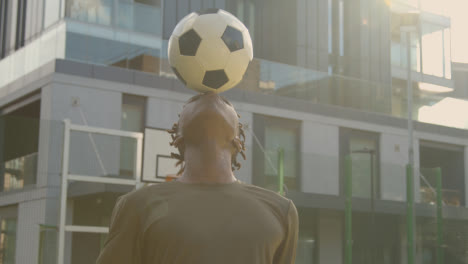 Primer-Plano-De-Una-Joven-Que-Coloca-El-Fútbol-En-El-Círculo-Central-De-Un-Campo-De-Fútbol-Artificial-En-Una-Ciudad-Urbana-Para-El-Inicio