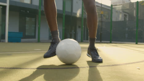 Männlicher-Fußballspieler-übt-Ballkontrolle-Auf-Künstlichem-Fußballplatz-Im-Stadtgebiet-Und-Balanciert-Fußball-Auf-Dem-Kopf-1