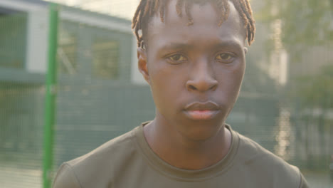 Portrait-Of-Serious-Young-Man-On-Sports-Pitch-In-Urban-City-Area-