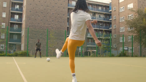 Jugadores-De-Fútbol-Entrenando-En-Un-Campo-De-Fútbol-Artificial-En-El-área-Urbana-De-La-Ciudad-Con-Una-Botella-De-Agua-En-Primer-Plano