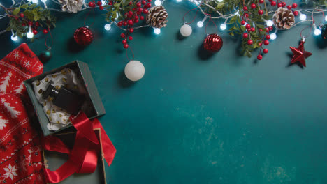 Überkopfaufnahme-Einer-Person-Mit-Heißem-Getränk-Im-Hintergrund-Mit-Weihnachtsschmuck-Und-Parfümgeschenk