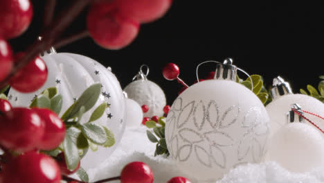Studio-Christmas-Still-Life-With-Tree-Decorations-And-Berries-On-Artificial-Snow