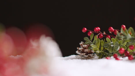 Studio-Christmas-Still-Life-With-Decorations-Berries-And-Pine-Cones-On-Artificial-Snow