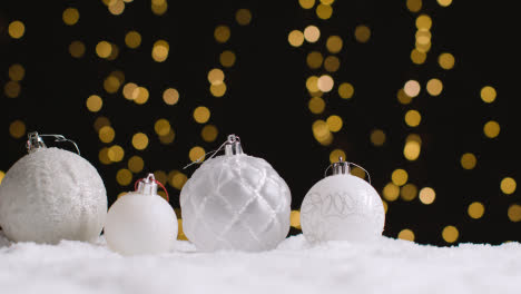 Studio-Christmas-Still-Life-With-Decorations-On-Snow-And-Lights-In-Background-1