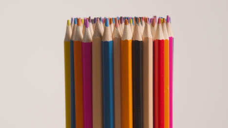 Studio-Shot-Of-Rotating-Multi-Coloured-Pencils-Against-White-Background