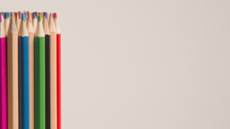 Studio-Shot-Of-Rotating-Multi-Coloured-Pencils-Against-White-Background-