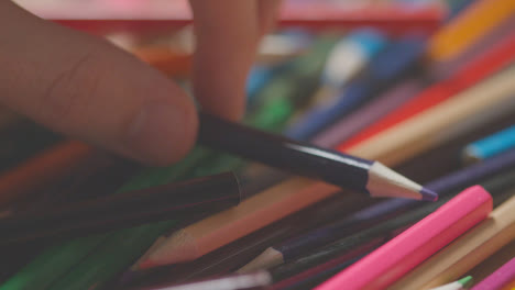 Full-Frame-Shot-Of-Multi-Coloured-Pencils-With-Hand-Reaching-In-To-Choose-Purple-One-1