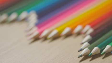 Foto-De-Estudio-De-Lápices-Multicolores-En-Una-Línea-Sobre-Fondo-De-Madera-3