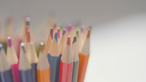 Close-Up-Of-Person-Dropping-Multi-Coloured-Pencils-Into-Pot