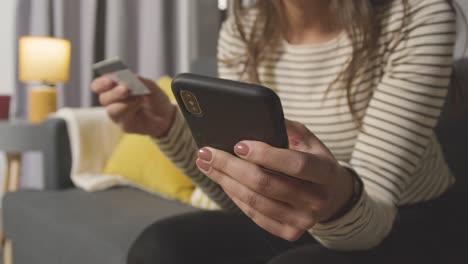 Close-Up-Of-Woman-At-Home-Shopping-Online-With-Credit-Card-Using-Mobile-Phone-1