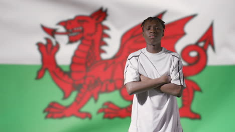 Junger-Fußballer,-Der-Vor-Der-Wales-flagge-Zur-Kamera-Geht-02