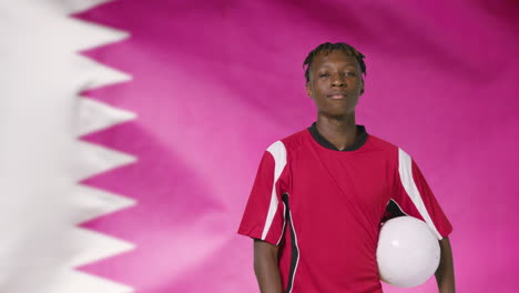 Young-Footballer-Walking-to-Camera-In-Front-of-Qatar-Flag-01