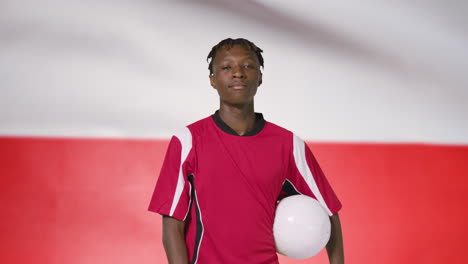 Young-Footballer-Walking-Holding-Football-In-Front-of-Poland-Flag-02