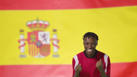 Junger-Fußballer,-Der-Vor-Der-Spanischen-Flagge-Vor-Der-Kamera-Feiert