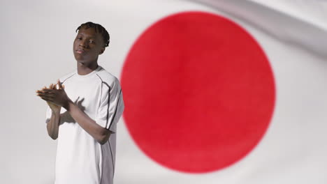 Junger-Fußballer,-Der-Vor-Japan-flagge-Aufwirft