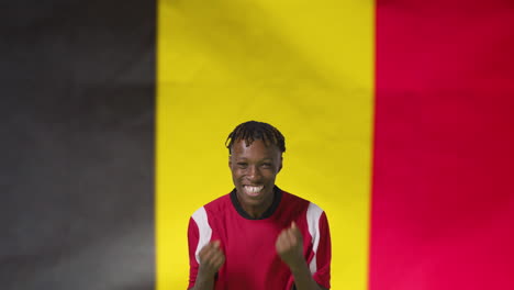 Joven-Futbolista-Celebrando-A-La-Cámara-Frente-A-La-Bandera-De-Bélgica-01