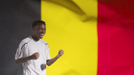 Joven-Futbolista-Celebrando-A-La-Cámara-Frente-A-La-Bandera-De-Bélgica-02