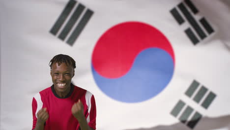 Joven-Futbolista-Celebrando-A-La-Cámara-Frente-A-La-Bandera-De-Corea-Del-Sur-01
