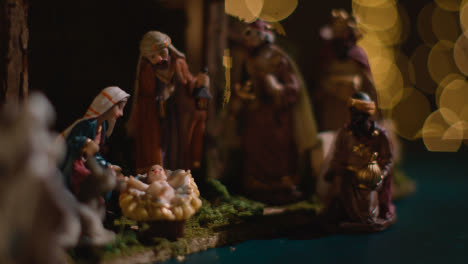 Studio-Christmas-Concept-Of-Baby-Jesus-In-Manger-With-Figures-From-Nativity-Scene-With-Lights-