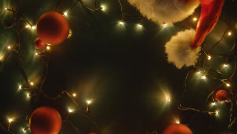 Overhead-Aufnahme-Des-Urlaubskonzepts-Mit-Rotierenden-Weihnachtsdekorationen,-Lichtern-Und-Weihnachtsmütze