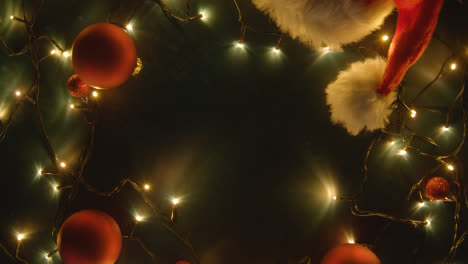 Overhead-Shot-Of-Holiday-Concept-Shot-With-Revolving-Christmas-Decorations-Lights-And-Santa-Hat-