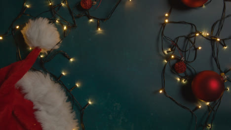 Overhead-Shot-Of-Holiday-Concept-Shot-With-Revolving-Christmas-Decorations-Lights-And-Santa-Hat-2