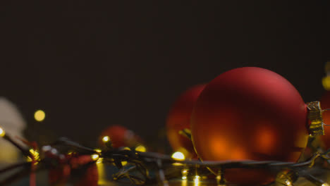 Holiday-Concept-Shot-With-Revolving-Christmas-Tree-Lights-Decorations-And-Santa-Hat-Against-Black-Background-1