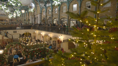 Luces-Y-Decoraciones-Navideñas-Con-Compradores-En-Covent-Garden,-Londres,-Reino-Unido-Por-La-Noche-1