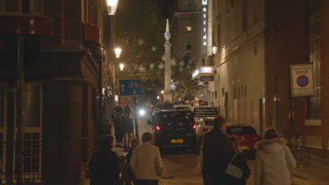 Luces-Y-Decoraciones-Navideñas-Con-Compradores-En-Cambridge-Circus-Covent-Garden,-Londres,-Reino-Unido-Por-La-Noche