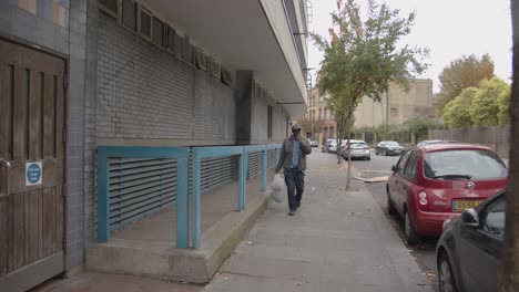 Hombre-Caminando-Por-La-Calle-Junto-Al-Desarrollo-De-Viviendas-Del-Centro-De-La-Ciudad-En-Tower-Hamlets-De-Londres