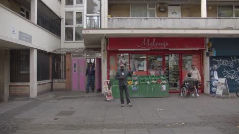 Tienda-En-El-Desarrollo-De-Viviendas-En-El-Centro-De-La-Ciudad-En-Tower-Hamlets,-Londres,-Reino-Unido-Con-Personas-1