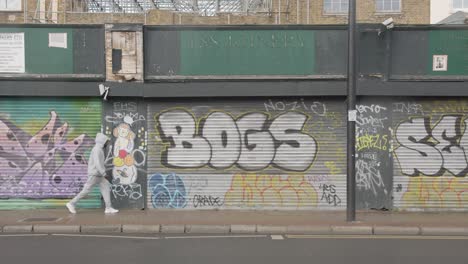 Geschlossene-Ladenfensterläden,-Die-Mit-Tags-Und-Graffiti-In-Tower-Hamlets,-London,-Großbritannien,-Sprühlackiert-Wurden-1