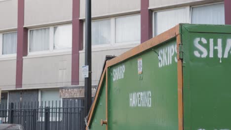 Waste-Skip-Outside-Inner-City-Housing-Development-In-Tower-Hamlets-London-UK