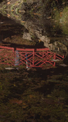 Video-Vertical-Del-Reflejo-Del-Puente-Sobre-El-Estanque-Con-Coloridas-Hojas-De-Otoño-En-El-Arboreto