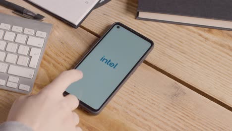 Teléfono-Móvil-En-El-Escritorio-Con-Pantalla-Que-Muestra-Logotipos-De-Marca-Para-Microsoft,-Intel,-Ibm,-Nvidia,-Adobe-Y-Qualcomm