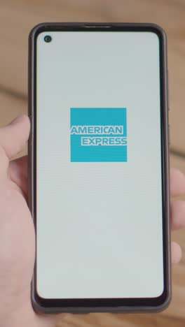 Vertical-Video-Of-Hand-Holding-Mobile-Phone-With-Screen-Showing-Brand-Logos-For-Mastercard,American-Express-and-Paypal