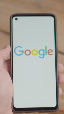 Vertical-Video-Of-Hand-Holding-Mobile-Phone-With-Screen-Showing-Brand-Logos-For-Google,Tik-Tok,Meta-and-Facebook