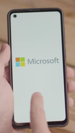 Vertical-Video-Of-Hand-Holding-Mobile-Phone-With-Screen-Showing-Brand-Logos-For-Microsoft,Intel,IBM,nVidia-and-Adobe