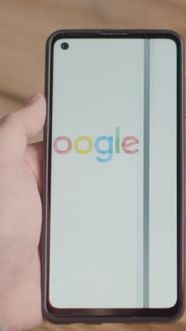 Vertical-Video-Of-Hand-Holding-Mobile-Phone-With-Screen-Showing-Brand-Logos-For-Apple,Google,McDonalds,Microsoft,Tesla-and-Verizon